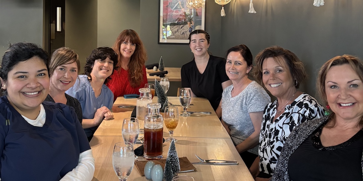 Dr. Deborah McNeil-Amorteguy and her team posing in front of their dental practice in San Luis Obispo, CO